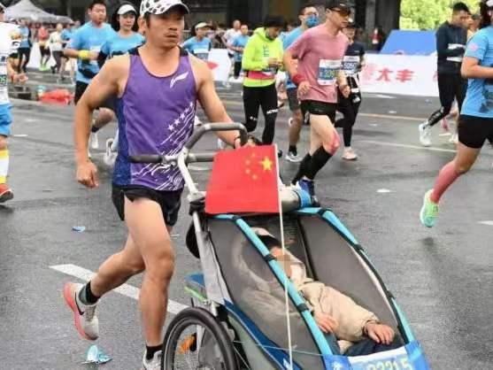 父亲推着脑瘫儿子跑完55场马拉松：（推着瘫痪儿子跑马拉松）